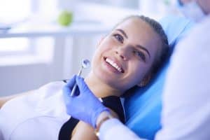 אישה מחייכת לאחר טיפול שיניים אצל הרופא שלה