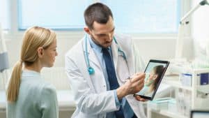 רופא מציג למטופלת תמונה על גבי אייפד