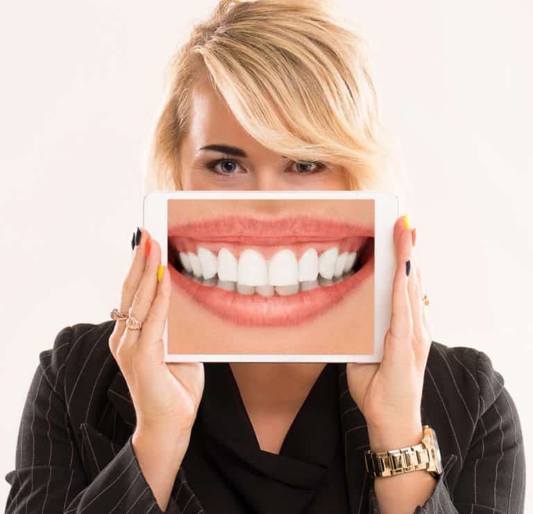 אישה מחזיקה טאבלט המציג את השיניים שלה